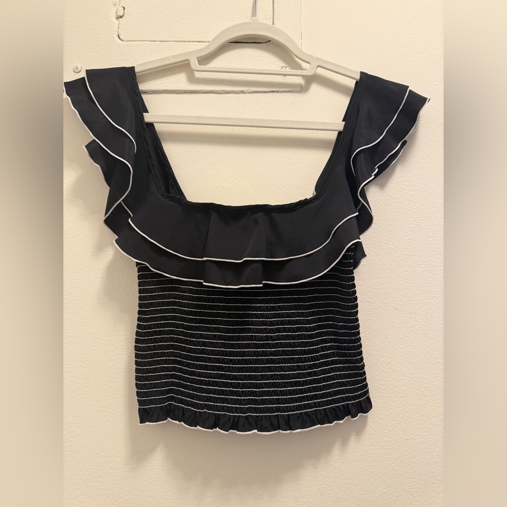 Likely black and white ruffled top